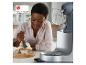 Femme décorant des cupcakes, avec un robot pâtissier à côté. Prix Red Dot 2020.