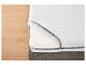 Un matelas blanc avec une fermeture éclair sur un lit.