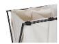 Gros plan sur un panier à linge en tissu beige à trois compartiments avec une structure métallique noire.