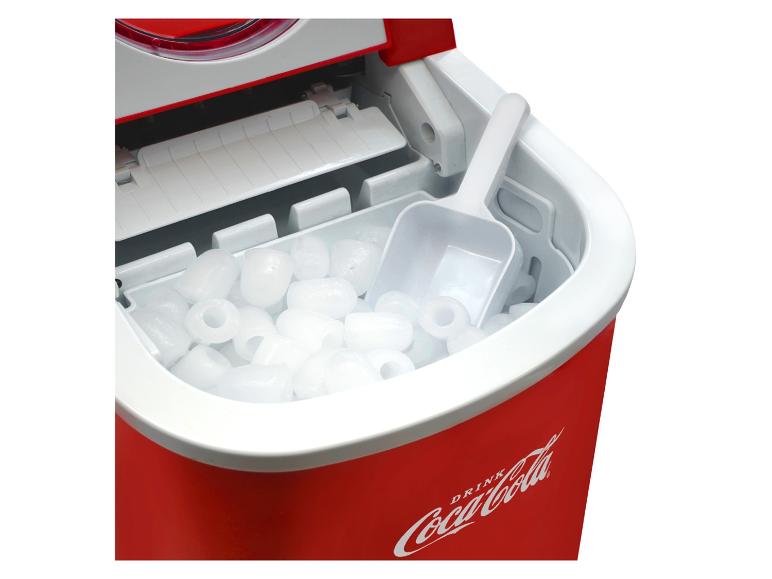 Une machine à glaçons Coca-Cola avec des glaçons et une pelle.