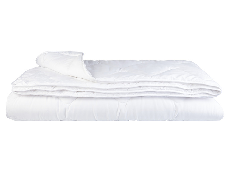Une couette blanche pliée sur un fond blanc.
