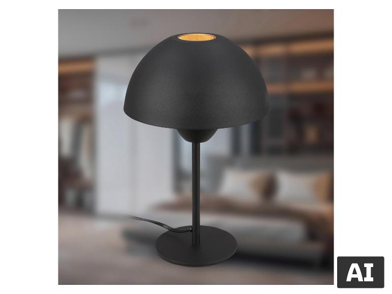 Lampe de table noire avec abat-jour en dôme, base ronde et cordon, sur fond flou.