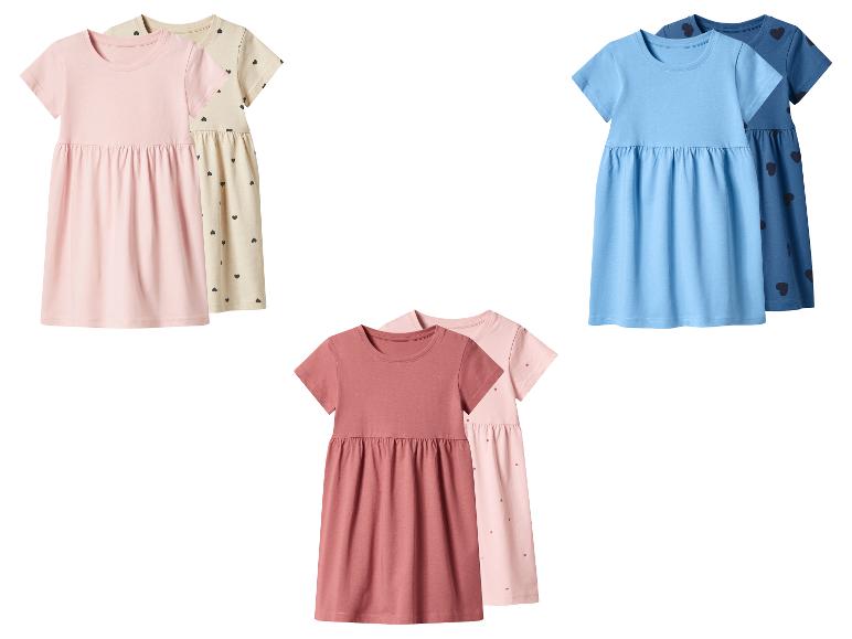 Trois ensembles de robes pour enfants de différentes couleurs, dont rose, bleu et marron.