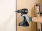 Une personne utilise une perceuse-visseuse sans fil Parkside pour visser dans une surface en bois.