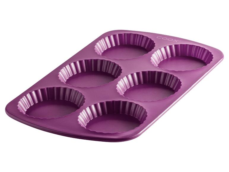 Un moule en silicone violet pour six petites tartes.