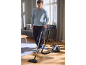 Homme passant l'aspirateur sur un parquet dans un salon.