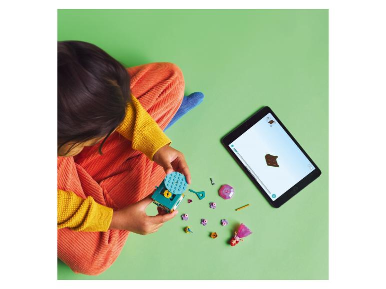 Un enfant joue avec des blocs LEGO et une tablette.