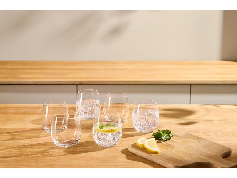 Verres d'eau avec citron et menthe sur un comptoir de cuisine en bois.