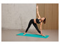 Une femme en tenue de sport fait du yoga sur un tapis bleu.