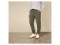 Un homme portant un pantalon de survêtement vert et des baskets blanches.