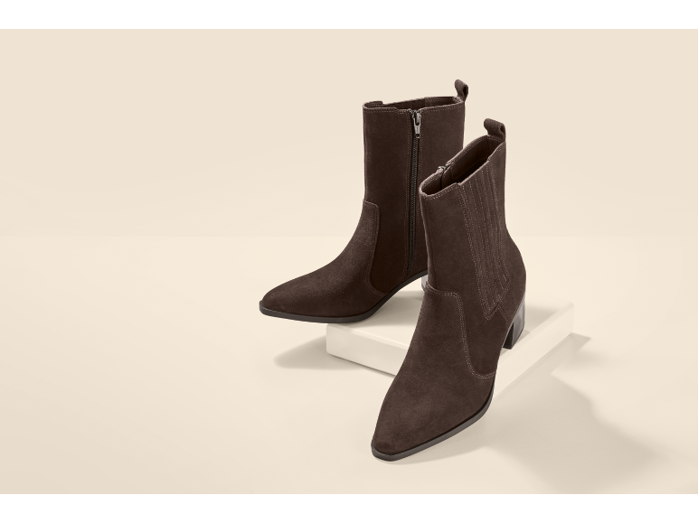 Une paire de bottines en daim marron à talons pour femme.