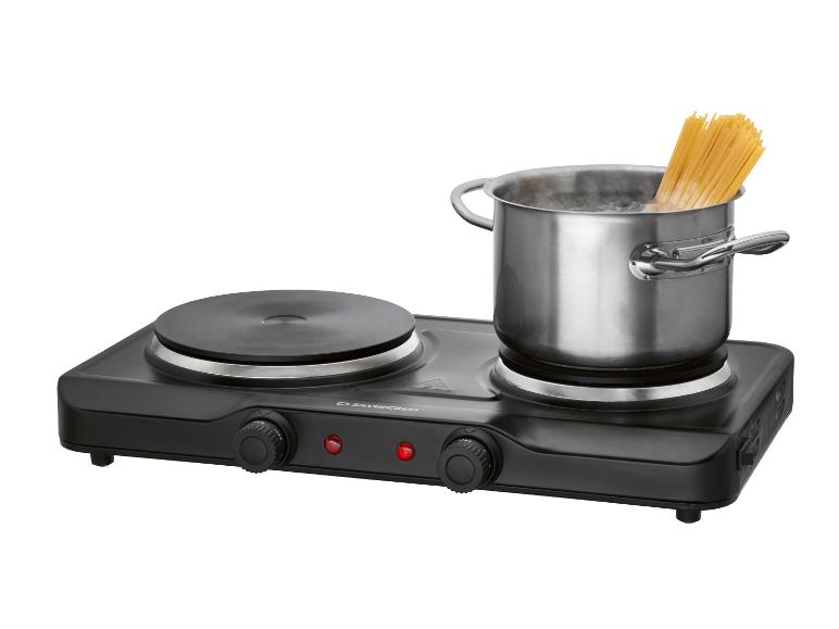 Plaque de cuisson électrique double avec une casserole d'eau bouillante et des spaghettis.