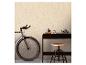Vélo et bureau avec tabouret contre un mur texturé.