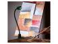 Lampe de travail à LED avec bras flexible éclairant une toile abstraite, avec une main tenant un pinceau et une palette.