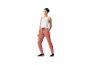 Une femme portant un débardeur blanc et un pantalon de jogging rose.