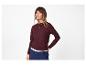 Femme en pull bordeaux, pantalon bleu marine et collier doré