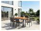 Ensemble de salle à manger d'extérieur avec table en bois et chaises en osier sur une terrasse moderne.