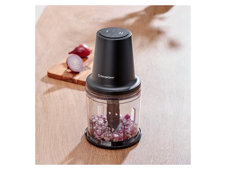 Hachoir SilverCrest avec oignon rouge haché sur une planche en bois.