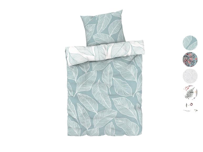 Une housse de couette et une taie d'oreiller avec un motif de feuilles blanches sur fond bleu.