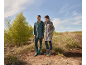 Homme et femme en imperméables et bottes dans la nature.