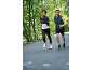 Deux coureurs en tenue de sport faisant du jogging en extérieur, femme en veste et homme en gilet.