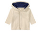 Un sweat à capuche crème pour bébé avec des boutons.