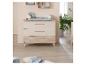Chambre d'enfant avec commode à langer, étagères et plantes.