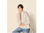 Femme souriante en pull à col roulé beige et jean bleu