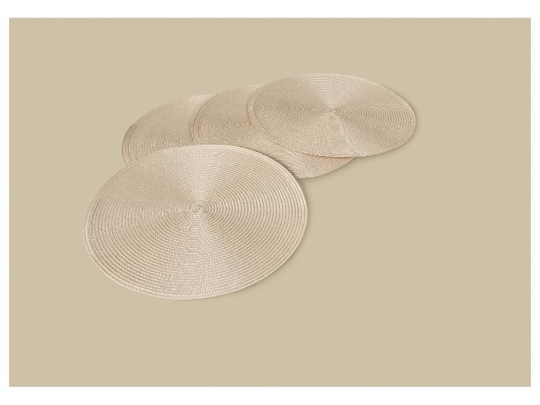 Quatre dessous de verre ronds beiges disposés sur une surface beige.