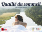 Une femme est allongée dans des draps blancs de Hna systèmes de sommeil avec vue sur un lac.