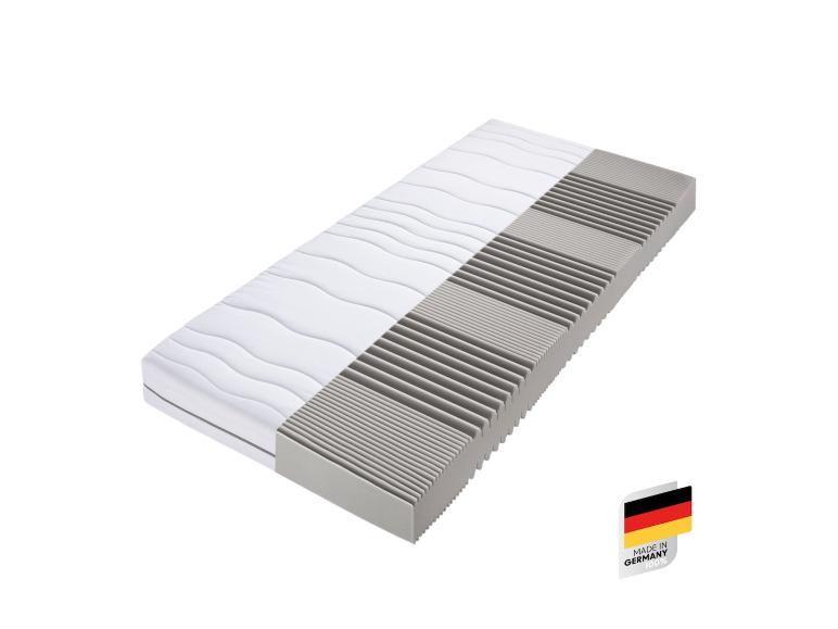 Un matelas blanc et gris avec une étiquette 'Made in Germany'.