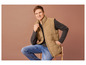 Un homme portant un gilet beige, un jean et un t-shirt gris.
