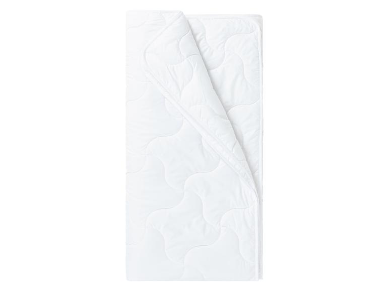 Couette blanche pliée, douce et confortable.