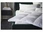 Une couette en duvet blanche sur un lit vert foncé