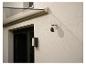 Caméra de sécurité extérieure fixée à un mur de maison sous un auvent en verre