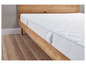 Un matelas blanc sur un cadre de lit en bois.