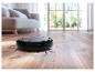 Aspirateur robot noir sur parquet dans un salon lumineux