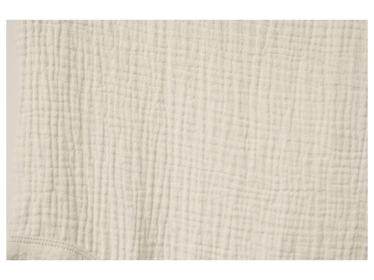 Tissu en mousseline de coton beige clair, texture douce.