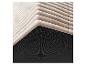 Détail d'un matelas avec une base noire à pois et une surface supérieure matelassée beige.