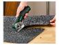 Cutter Parkside coupant un tapis.