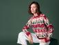 Une femme porte un pull de Noël rouge à motif d'homme en pain d'épices.