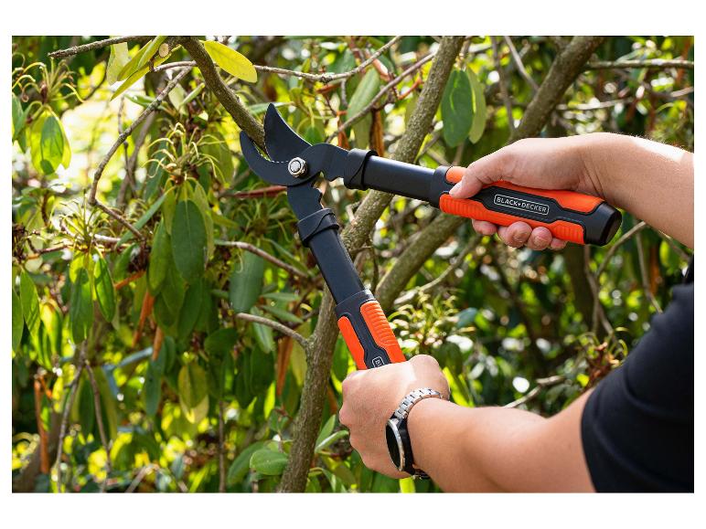 Personne taillant une branche avec un sécateur de jardin à poignées oranges.