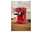 Machine à expresso rouge sur un comptoir de cuisine, avec des grains de café et du café moulu.