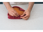 Mains détachant un moule à gâteau en silicone en forme de cœur avec un gâteau cuit à l'intérieur.