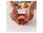 Une main tenant un moule à pâtisserie en silicone rouge avec un gâteau aux fruits