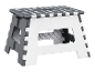 Un tabouret pliable gris et blanc à pois.
