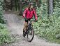 Une femme fait du vélo de montagne dans une forêt.