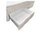 Lit avec matelas blanc et tiroir de rangement ouvert avec doublure en tissu beige.