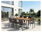 Ensemble de mobilier de jardin avec table en bois et huit chaises sur une terrasse.