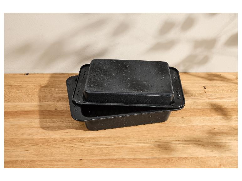 Deux rôtissoires rectangulaires noires à finition mouchetée sur une surface en bois.